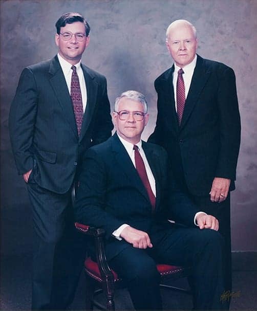 Three men in suits posing for a portrait.