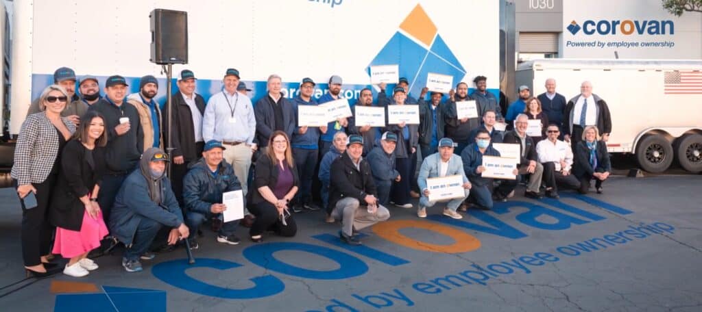 Corovan employees group photo with ownership signs